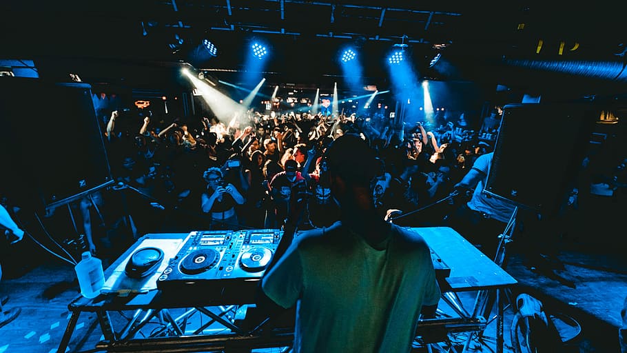 man performing DJ music with crowd during nighttime, man standing on stage in front of people and turntable, HD wallpaper